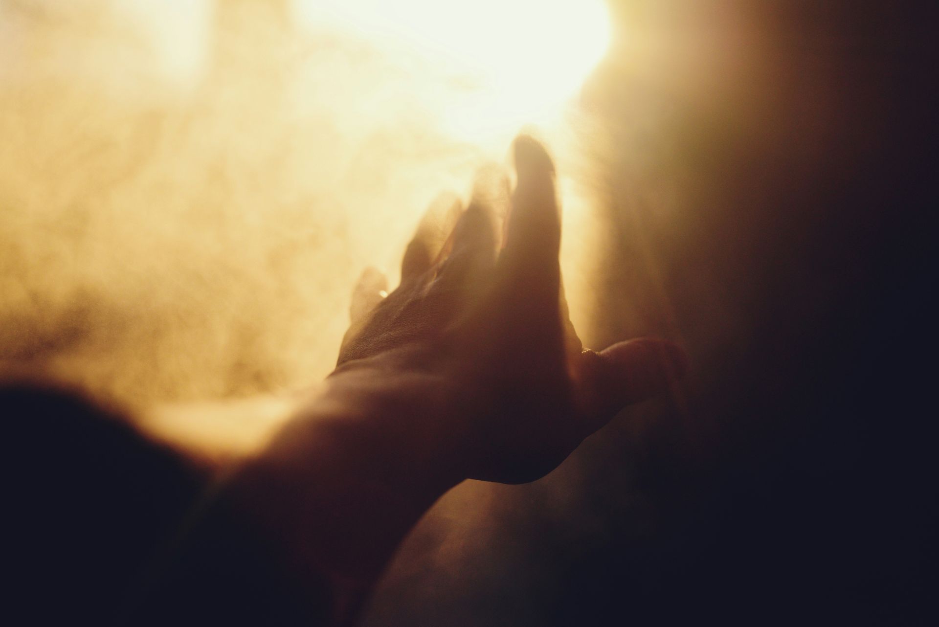 A hand reaching towards a bright light